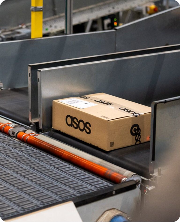 An asos box on a conveyor belt in a warehouse represting the Nomagic Spot solution
