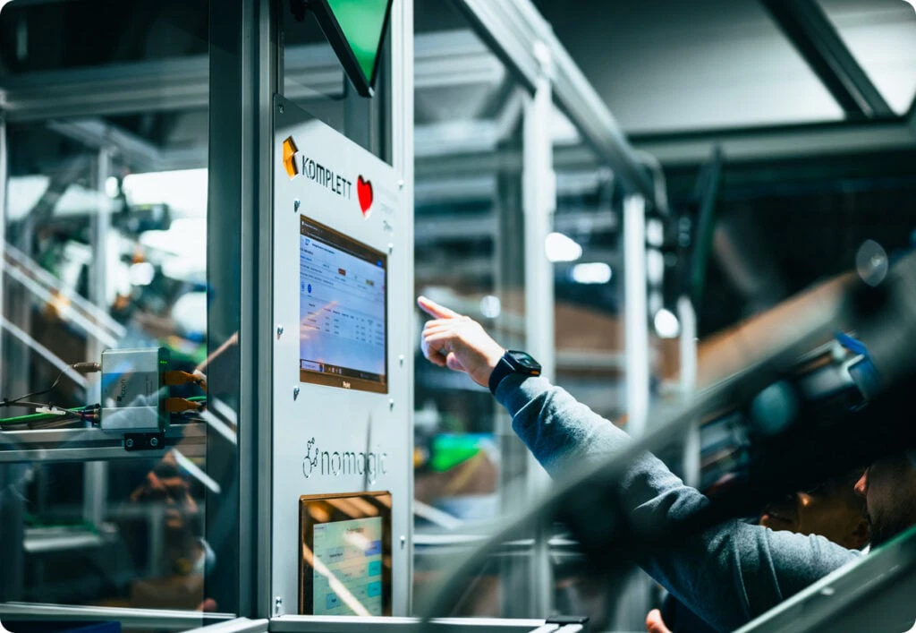 Une main pointant vers un écran de contrôle Nomagic