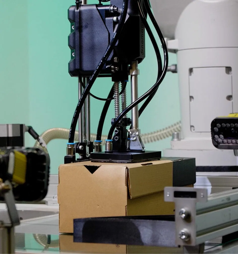 Un robot Nomagic de ramassage de boîtes à chaussures tenant une boîte à chaussures