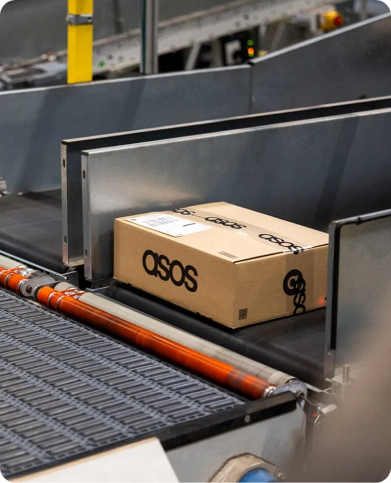 An asos box on a conveyor belt in a warehouse represting the Nomagic Spot solution