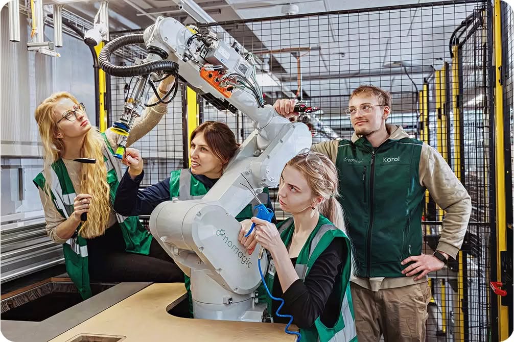 Personal de Nomagic alrededor de un robot de Nomagic